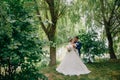 The bride and groom are kidnapped in nature, strolling in the park near the pond and listening to the singing of birds. Royalty Free Stock Photo