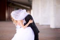 The bride and groom kiss, hiding in a veil, behind which no faces are visible. Royalty Free Stock Photo