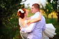 The bride and groom are kissing in the apple orchard, standing u