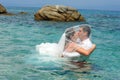 Bride & groom kissing in the clear blue sea water Royalty Free Stock Photo