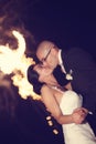 Bride and groom kissing with fireworks in background