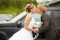 Bride and groom kissing near a car Royalty Free Stock Photo