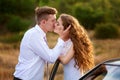 Bride and groom kissing near car on wedding walk Royalty Free Stock Photo