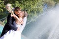 A bride and a groom kissing near the fountain Royalty Free Stock Photo