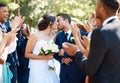 Bride and groom kissing after wedding ceremony while friends and family clap and celebrate their wedding day Royalty Free Stock Photo