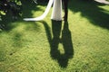 Bride and groom legs standing on green lawn. Shadow silhouette revealing their kissing. Wedding day concept. Royalty Free Stock Photo