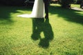 Bride and groom legs standing on green lawn. Shadow silhouette of their kiss. Shallow depth of field. Wedding day Royalty Free Stock Photo