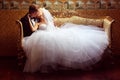 Bride and groom on a luxury hotel, kissing on a sofa