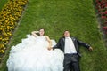 Bride and groom lying on lawn with flowers Royalty Free Stock Photo