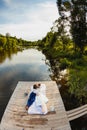 Bride and groom lying on a wooden pier near the pond Royalty Free Stock Photo