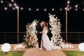 The bride and groom near the arch at the evening ceremony. Royalty Free Stock Photo