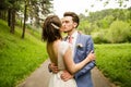 Bride and groom in a park kissing.couple newlyweds bride and groom at a wedding in nature green forest are kissing photo portrait. Royalty Free Stock Photo