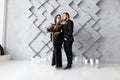 Bride and groom portrait in studio. Isolated on gray geometric background. Dry ice smoke on floor