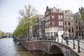 bride and groom pose near canal in centre of dutch capital Amsterdam