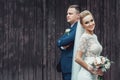 Bride and groom are posing near the old brown wooden house Royalty Free Stock Photo