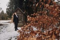 Bride and groom posing at old well with moss in autumn garden. happy newlywed couple embracing at wooden house in woods. gorgeous Royalty Free Stock Photo