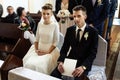Bride and groom preparing for communion on knees at wedding ceremony in church