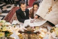 Bride and groom pronouncing vows, holding hands on bible on altar and priest holding golden cross on hands during holy matrimony
