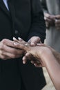 Bride and groom putting rings on each other`s fingers during outdoor wedding Royalty Free Stock Photo