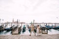 The bride and groom are run along the gondola pier, holding hand in Venice, near Piazza San Marco, overlooking San Royalty Free Stock Photo