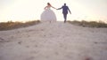 Bride and groom run along white road to the sky, slow motion shooting