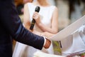Bride and groom's hands wrapped in priest's cassock Royalty Free Stock Photo