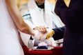 Bride and groom's hands wrapped in priest's cassock
