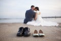 Bride and groom shoes with couple out of focus kissing in background