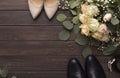 Bride groom shoes and roses bouquet on wooden floor