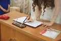 Bride and groom signing marriage wedding certificate at registry. Royalty Free Stock Photo