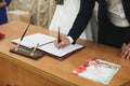 Bride and groom signing marriage wedding certificate at registry. Royalty Free Stock Photo