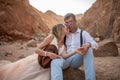 Bride and groom sit and hold hands in canyon. Closeup. Royalty Free Stock Photo