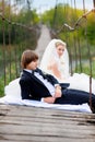 Bride groom sitting on the bridge Royalty Free Stock Photo