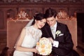 Bride and groom sitting on royal chairs