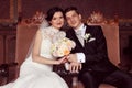 Bride and groom sitting on royal chairs