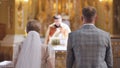 A bride and groom stand back to back in a Catholic church during their wedding. Royalty Free Stock Photo