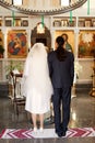 The bride and groom stand on an embroidered towel during a church wedding