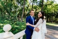 The bride and groom stand on the stairs in the park. The bridegroom embraces the bride. Wedding couple in love at wedd day Royalty Free Stock Photo