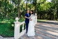 The bride and groom stand on the stairs in the park. The bridegroom embraces the bride. Wedding couple in love at wedd day Royalty Free Stock Photo