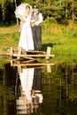 Bride and groom are standing on a bridge near the forest Royalty Free Stock Photo