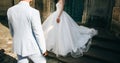 Bride and groom standing near ancient doors in the old town street. Wedding couple in love. Luxury rhinestone dress. Hot summer Royalty Free Stock Photo