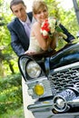 Bride and groom standing near wedding car Royalty Free Stock Photo