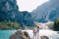 The bride and groom are standing on stones overlooking the Lago di Braies in Italy. Destination wedding in Europe, on Royalty Free Stock Photo