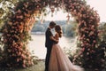 A bride and groom standing together in front of a beautifully decorated floral arch, An intimate garden wedding beneath a floral