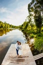 The bride and groom are standing on a wooden pier near the pond Royalty Free Stock Photo