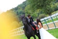 Bride and groom at stud black horse Royalty Free Stock Photo