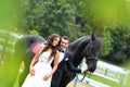 Bride and groom at stud black horse Royalty Free Stock Photo