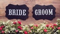Bride and Groom text sign on wooden background decorated with flower, vintage style. wedding sign concept. Royalty Free Stock Photo