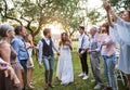 Bride, groom and guests at wedding reception outside in the backyard.