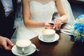 Bride and groom on their wedding day, drink coffee in a cafe Royalty Free Stock Photo